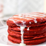 stack of Red Velvet Pancakes with a white chocolate drizzle