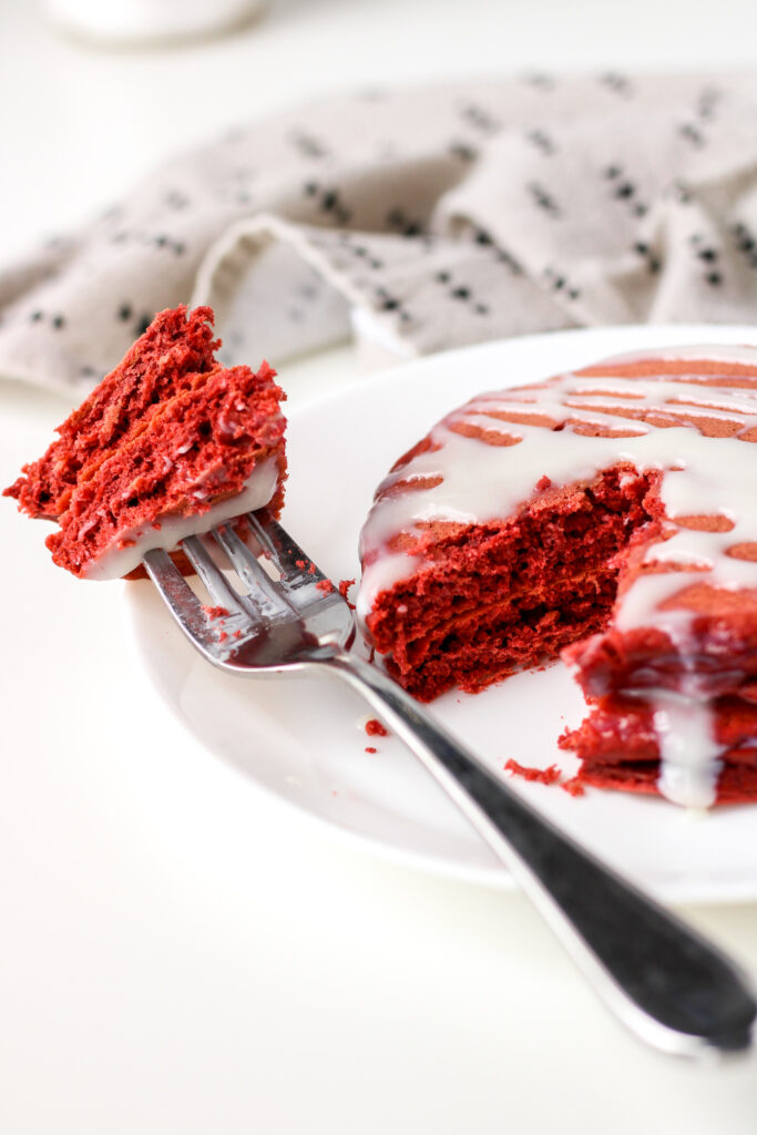 Red Velvet Pancakes on a plate with a bite of pancakes on a fork