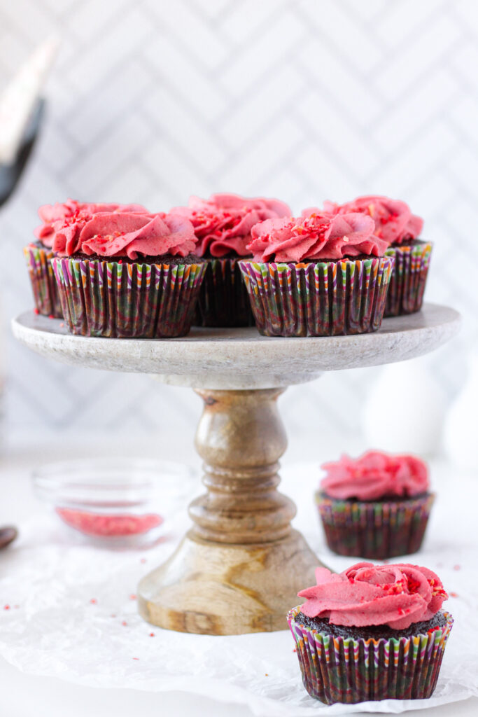Vegan Chocolate Cupcakes with Strawberry Coconut Cream on a cake stand