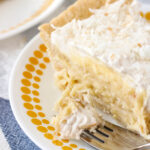 Coconut Cream Pie on a plate with a bite on a fork