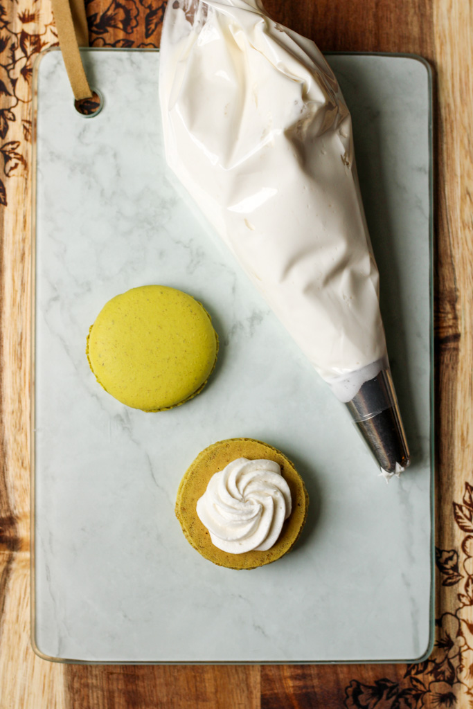 Dairy Free Pistachio and Marshmallow Macarons on a cutting board | Bakes and Blunders