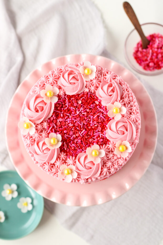 Wafer Paper Strawberry Blossoms on a pink cake with pink sprinkles