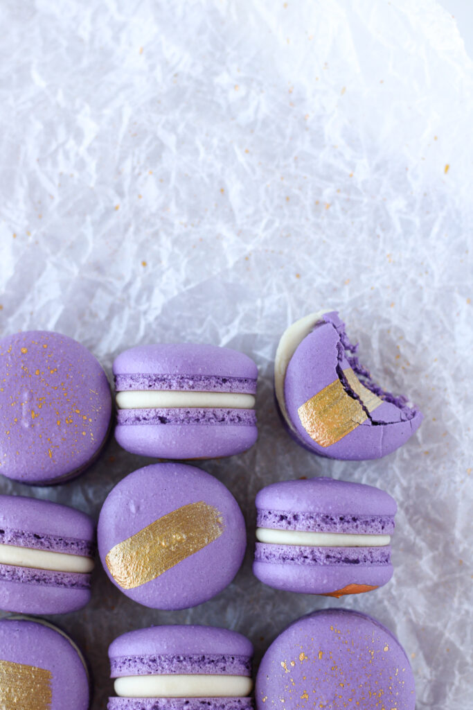 purple macarons with edible gold paint decoration