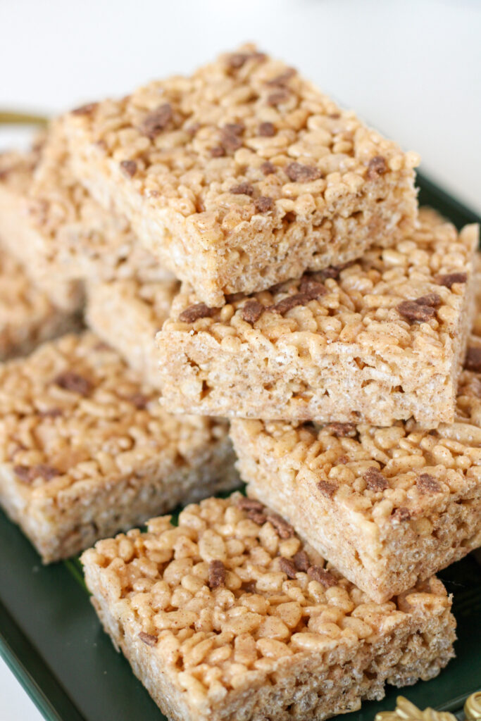 Rice Krispie Treats stacked on a dark green serving tray
