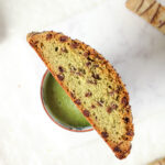 Matcha Chocolate Chip Biscotti on a mug with matcha latte