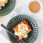 Maple Orange Bread Pudding on a green plate with a cup of tea