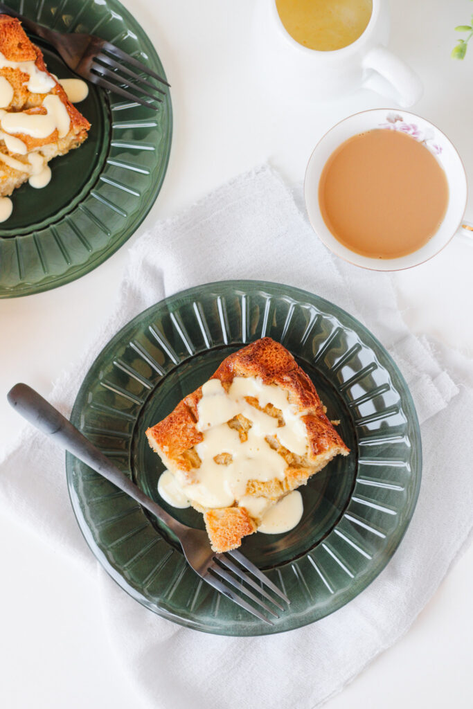 Maple Orange Bread Pudding on a green plate with a cup of tea