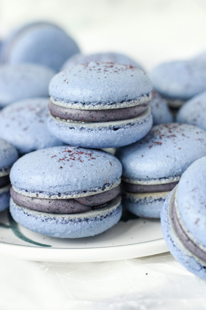 Blueberry Yuzu Macarons stacked on a plate